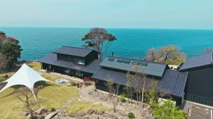 福井・ワクテラス。日本海を望む高台に建つ黒瓦の和建築を空から望む