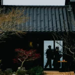ワクテラスの黒瓦の外観と、紅葉の庭のたたずまい