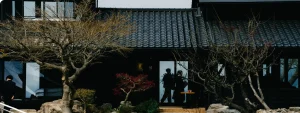 ワクテラスの黒瓦の外観と、紅葉の庭のたたずまい