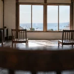 客席の後ろから見た、椅子の並ぶ室内と窓
